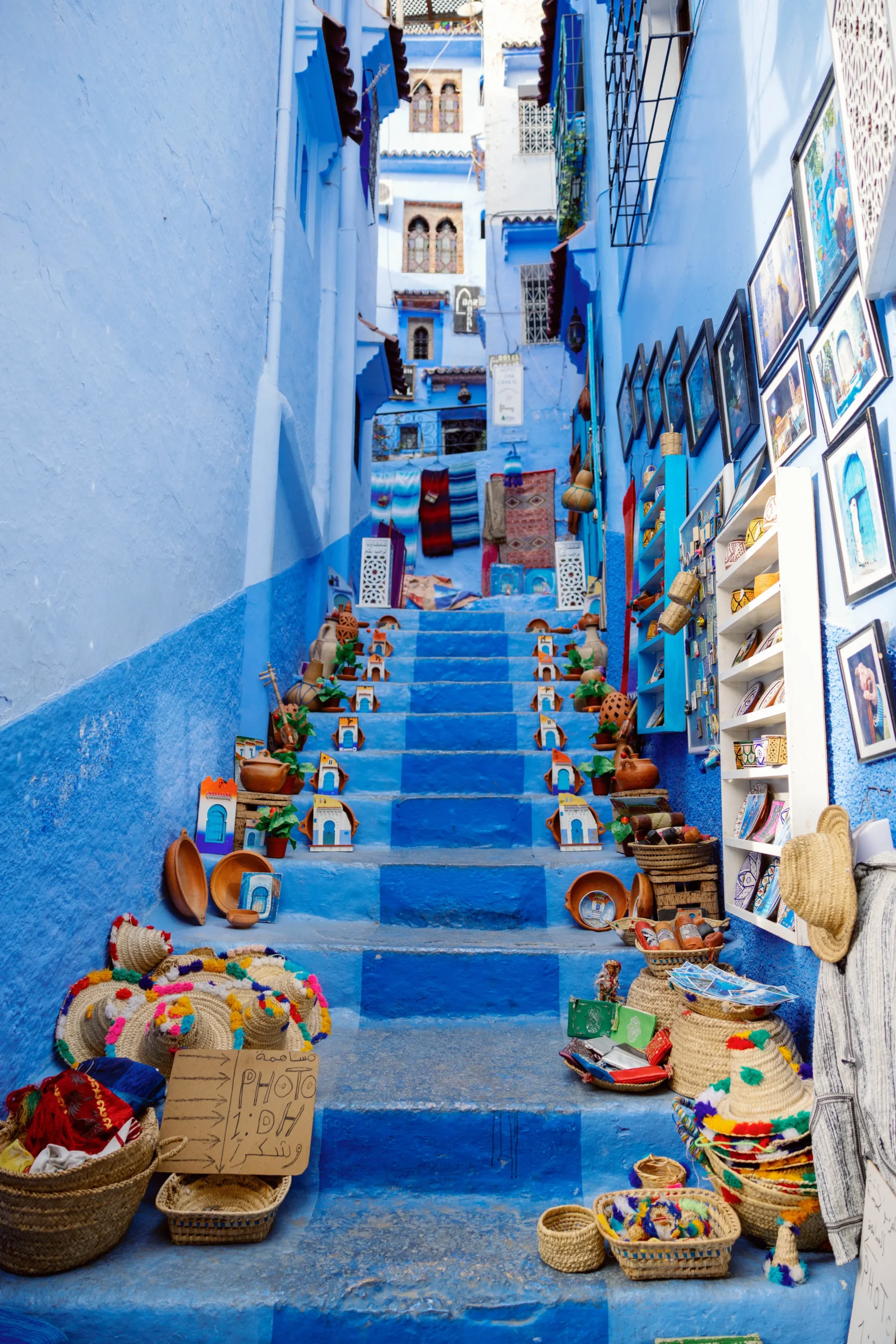 morocco tours packages Chefchaouen blue stairs with traditional handicrafts and Moroccan souvenirs
