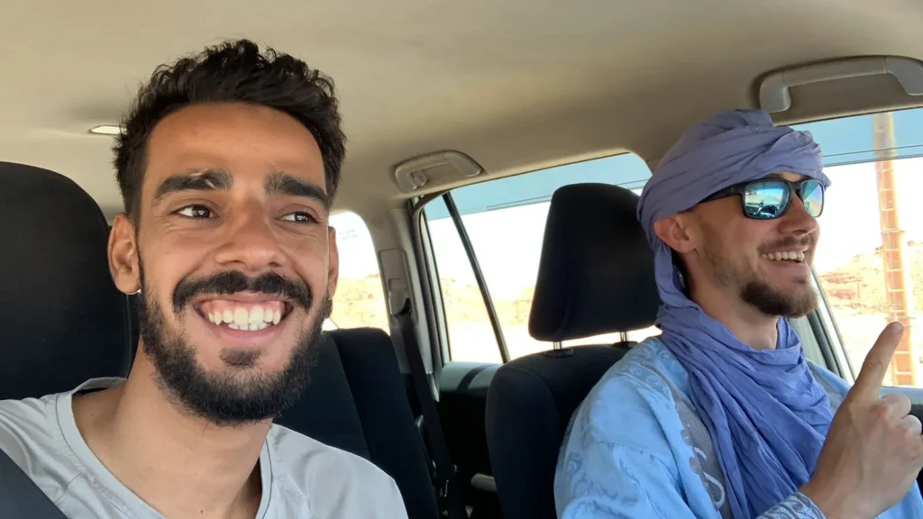 Morocco tour packages happy tourist with friendly Moroccan driver guide in private vehicle during desert tour